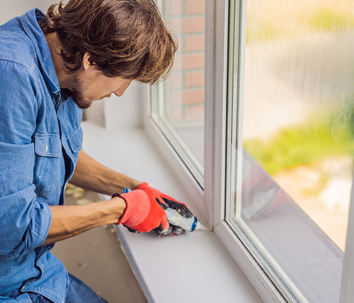 man insulating window